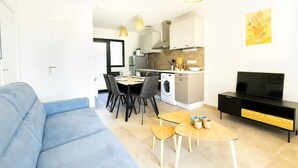 Un appartement moderne comprenant un salon, un coin repas, une cuisine et un téléviseur.