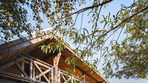 Une cabane en bois dotée d’une piscine, d’un espace salon extérieur et d’une grande fenêtre donnant sur le paysage.