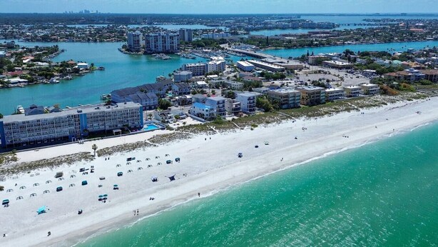 A coastal area with a beach, marina, and residential buildings.