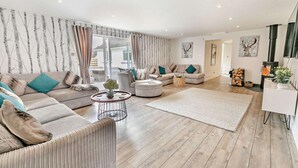 A modern living room with a large sectional sofa, a round coffee table, and a fireplace.