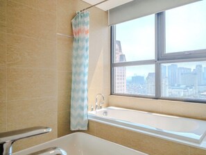 A bathroom with a bathtub, a window with a city view, and a shower curtain. - Vinhomes Skylake by Serene Homestay (Hanoi)