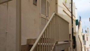 A narrow street with a white staircase leading to a building.