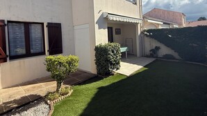 A two-story house with a garage, a small garden, and a paved driveway. - Cosy house 300m from the beach (La Tranche-sur-Mer)
