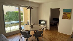 A modern living room with a dining area, a TV, and a painting on the wall. - Cosy house 300m from the beach (La Tranche-sur-Mer)