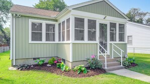 A small, single-story house with a front porch, a covered entryway, and a small garden area with various plants. - < 1 Mi to Colonial Beach: Coastal Gem w/ 2 Porches (Colonial Beach)