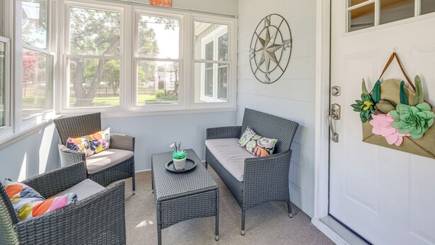 A sunroom with wicker furniture, a small table with a plant, and a decorative wall piece. - < 1 Mi to Colonial Beach: Coastal Gem w/ 2 Porches (Colonial Beach)