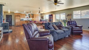 A spacious living room with leather chairs, a grey sofa, and a ceiling fan. - Panoramic Vistas and Spacious: Silver City Escape (Silver City)
