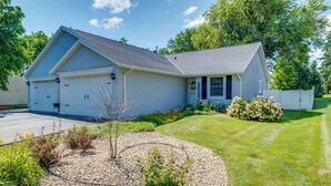 A two-story house with a garage, a well-maintained lawn, and a small garden area.