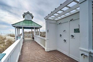 A wooden deck with a covered area and a sign indicating a restroom. - Marina & Pool: Roomy Golf-view Home in Southport (St. James)