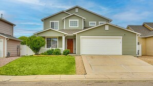 A two-story house with a front garage, a well-maintained lawn, and a small tree in the front yard. - Family Home w/ Fenced Yard in Pueblo: 5 Mi to Dtwn (Pueblo)