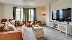 A modern living room with a sofa, bean bag chairs, a TV, and a console table. - Family Home w/ Fenced Yard in Pueblo: 5 Mi to Dtwn (Pueblo)