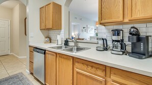 A modern kitchen with wooden cabinets, stainless steel appliances, and a dishwasher.