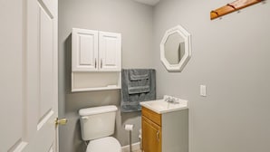 A bathroom with a toilet, a sink, a mirror, and a cabinet. - Shared Outdoor Space: Quaint Studio in Fredonia (Fredonia)