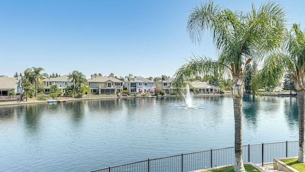 A residential area with a calm lake, a fountain, and houses with a fence in the foreground. - 3 Mi to Main St Tracy: Homey Retreat w/ Game Room! (Tracy)