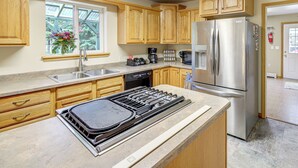 Una cocina con armarios de madera, un refrigerador de acero inoxidable, una estufa y un lavavajillas.