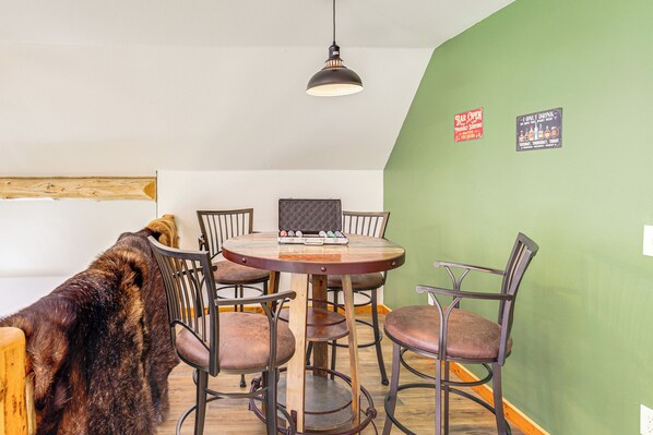 A dining area with a round table, six chairs, and a hanging light fixture. - Private Hot Tub: 'enchanted Hideaway' in Lincoln! (Lincoln)