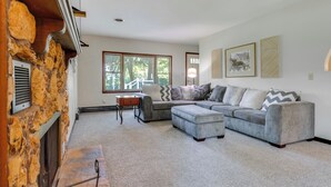 A living room with a stone fireplace, a sectional sofa, and a small table. - 9 Mi to Downtown Rushville: Cozy Getaway w/ Grill (Rushville)