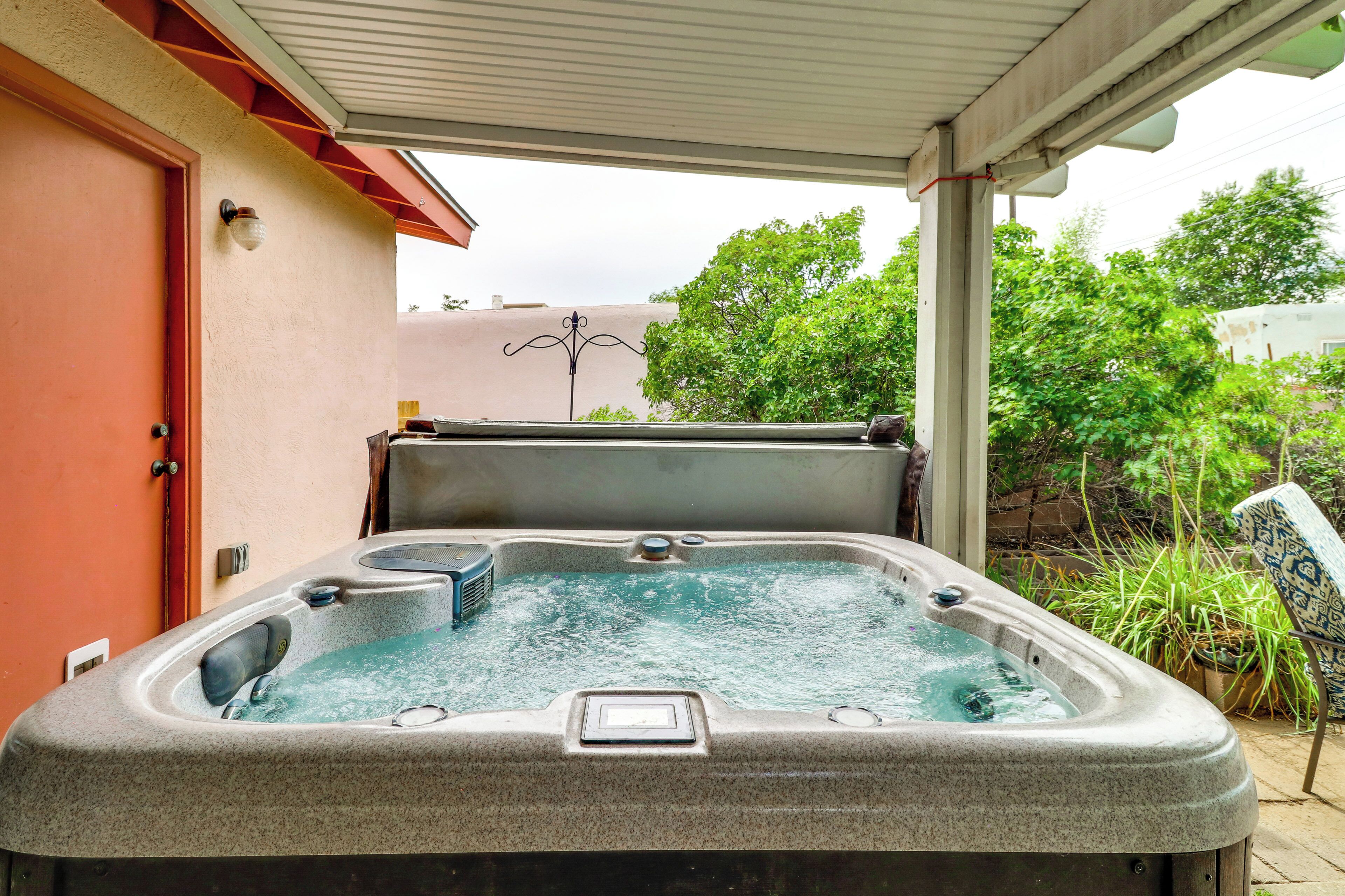 A hot tub with a built-in heater, located in an outdoor patio area with a covered roof.