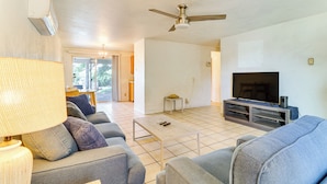 A living room with a sofa, a coffee table, a television, and a ceiling fan. - Pets Welcome: Hot Tub Haven in Albuquerque! (Albuquerque)