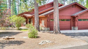 A red cabin with a stone foundation, surrounded by tall pine trees and a gravel driveway. - Golf & Mountain Views - Retreat in Clio (Clio)