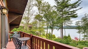 A balcony with a wooden railing, a table, and two chairs. - Beech Mt Lakefront Gem! Hot Tub, Kayaks, Billiards (Drums)