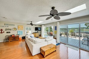 A spacious living room with a white sofa, wooden coffee table, and a ceiling fan.