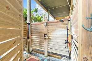 A wooden outdoor shower area with a rain shower head, a hose, and a soap dispenser. - Private Pool & Hot Tub, 360° Porch, Steps to Beach (Port St. Joe)