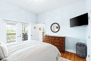 A bedroom with a bed, dresser, and a television on the wall. - Private Pool & Hot Tub, 360° Porch, Steps to Beach (Port St. Joe)