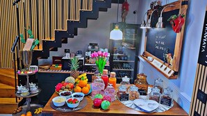 A breakfast setup with a variety of fruits, pastries, and a coffee machine. - Roby's boutique rooms (Catania)