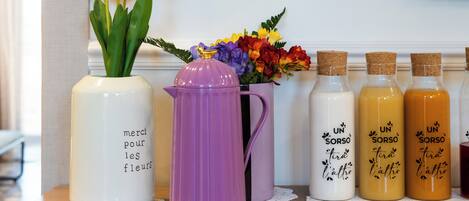 A table with vases, bottles, and a flower arrangement.