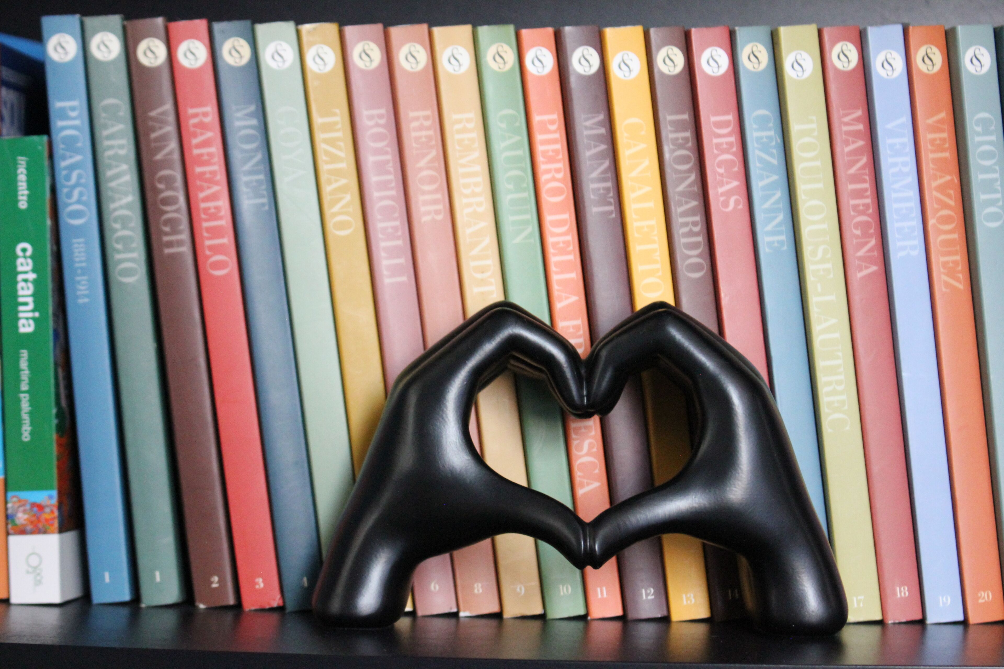 Ein Bücherregal mit farblich sortierten Büchern.