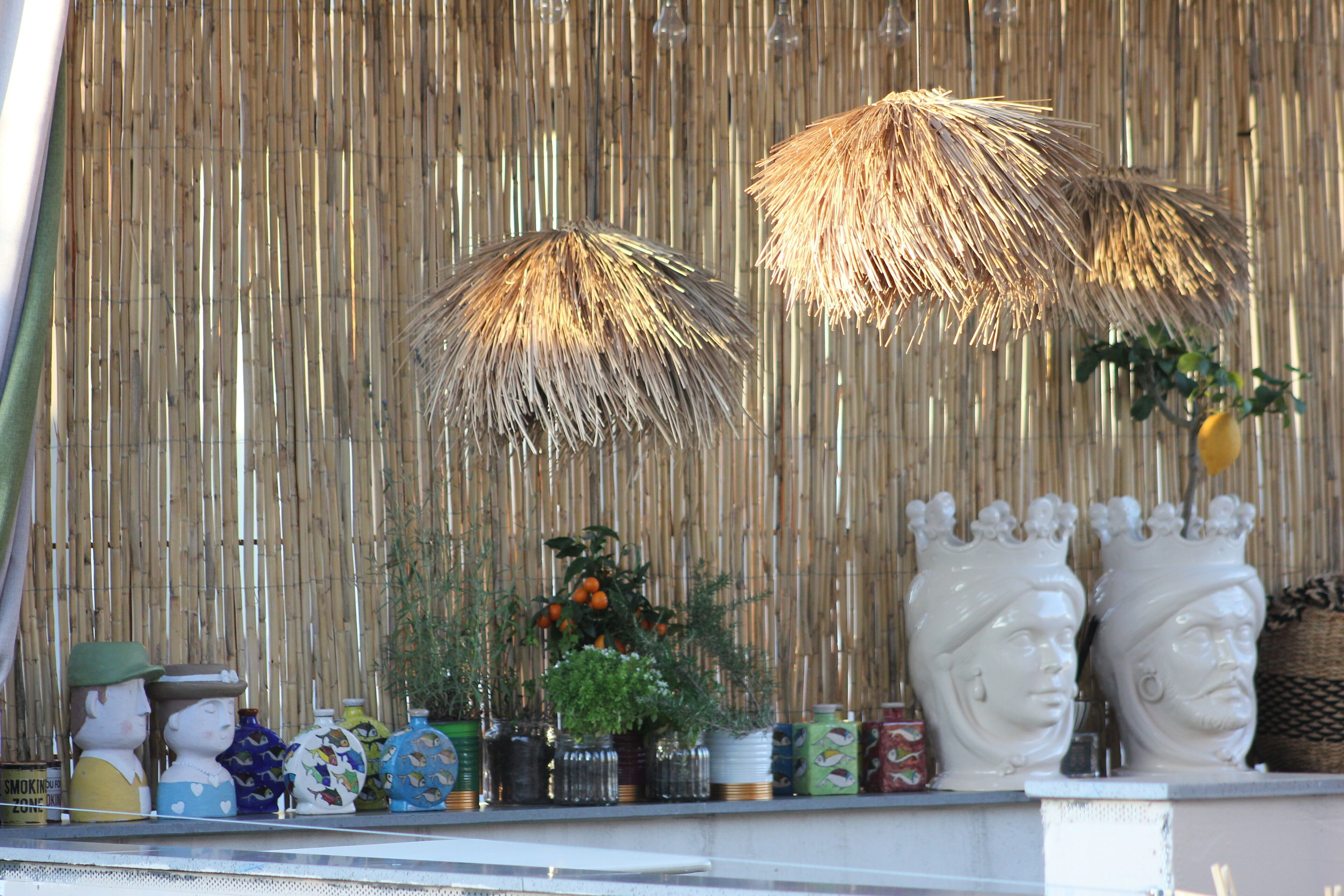 Una estantería con diversos objetos decorativos, como jarrones, una planta y figuritas.