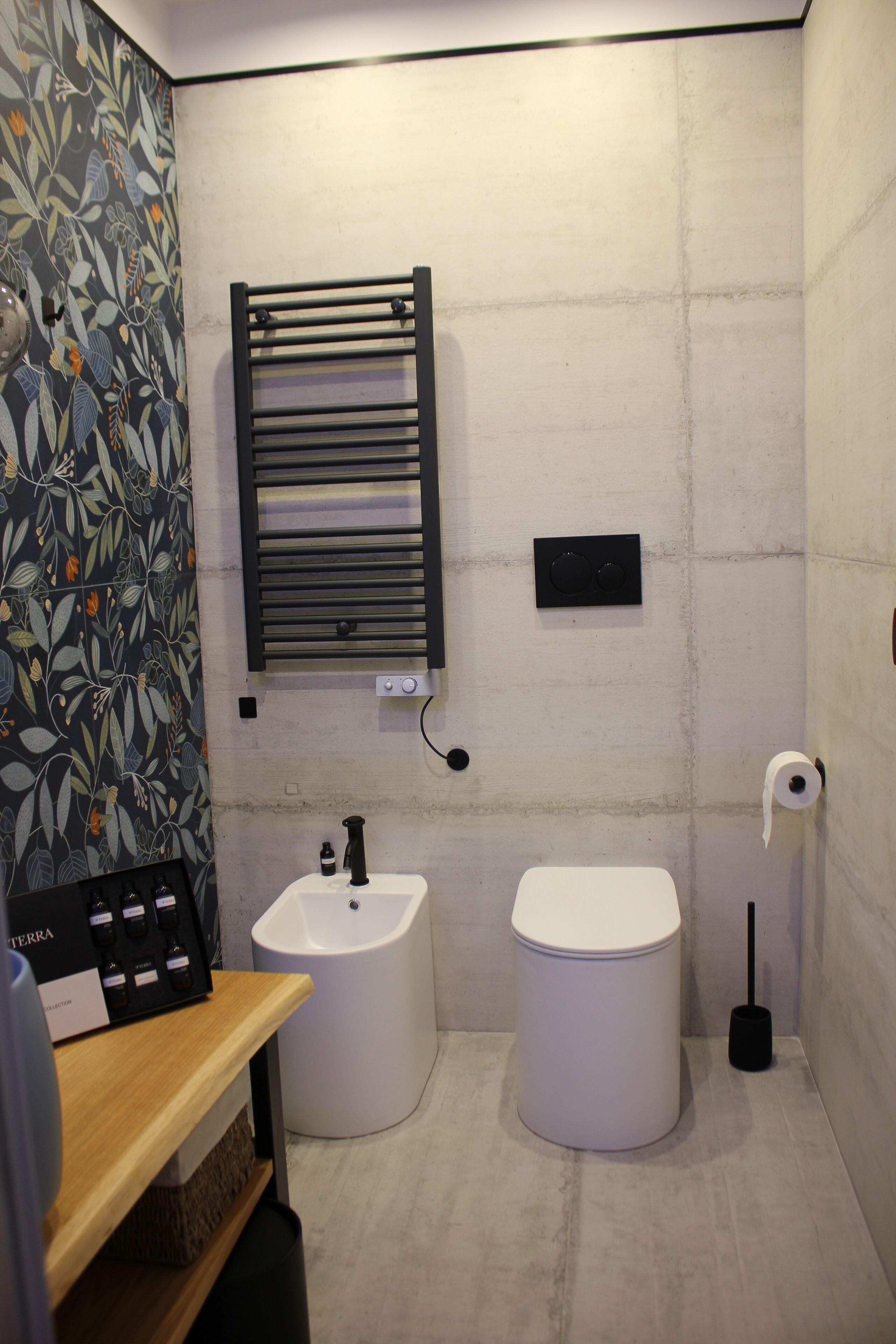 Une salle de bain moderne équipée de toilettes, d’un lavabo et d’un porte-serviettes.