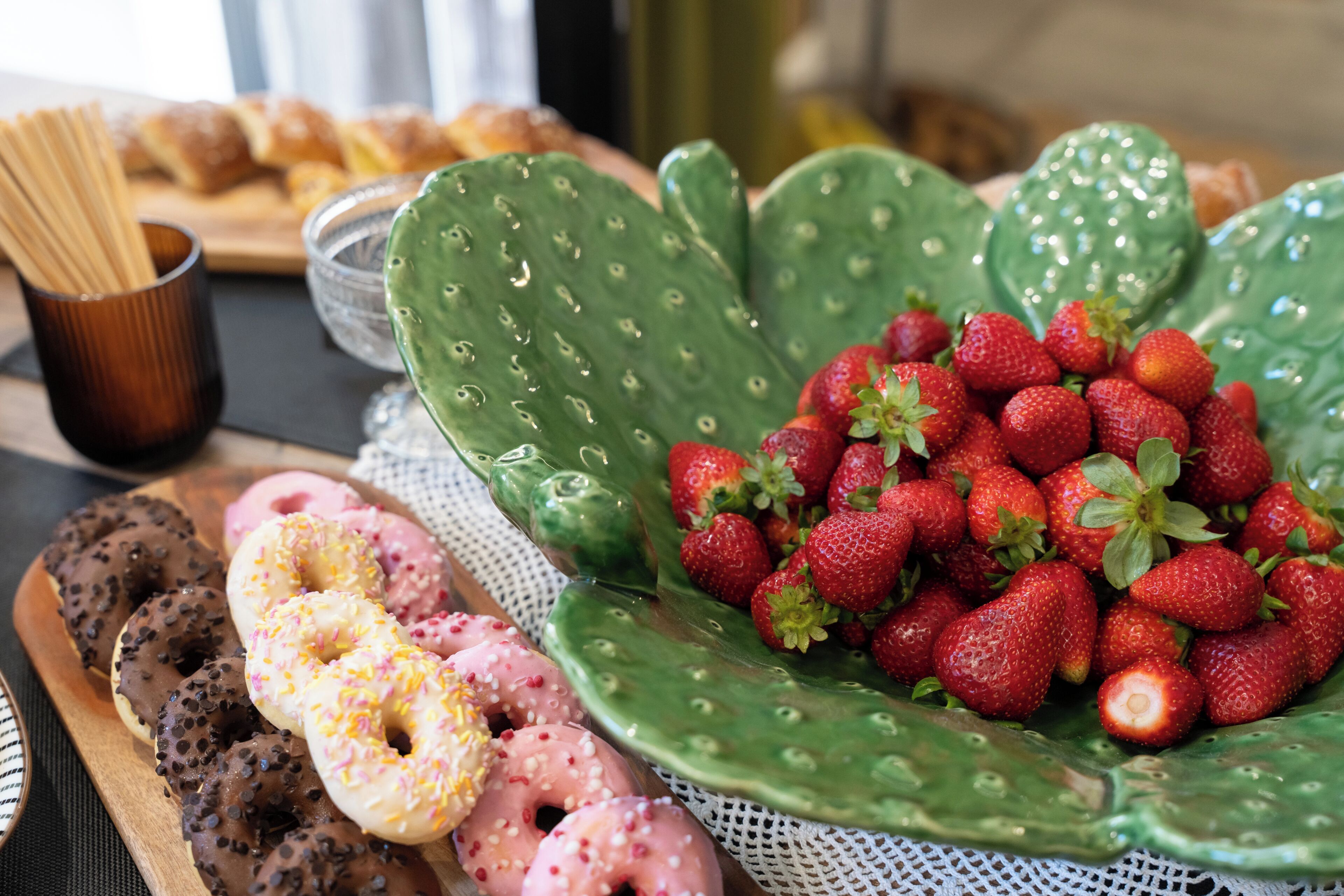 Un plateau avec un assortiment de beignets et un bol de fraises.