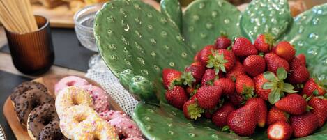 Un plateau avec un assortiment de beignets et un bol de fraises.