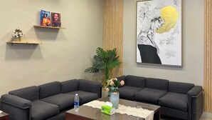 A modern living room with a sectional sofa, a coffee table, and decorative items. - Houres Hotel (Cairo)