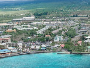 A coastal town with buildings, a marina, and a road leading to the beach.