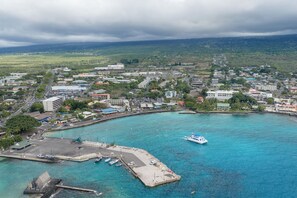 A coastal town with a marina, buildings, and a boat docked in the water.