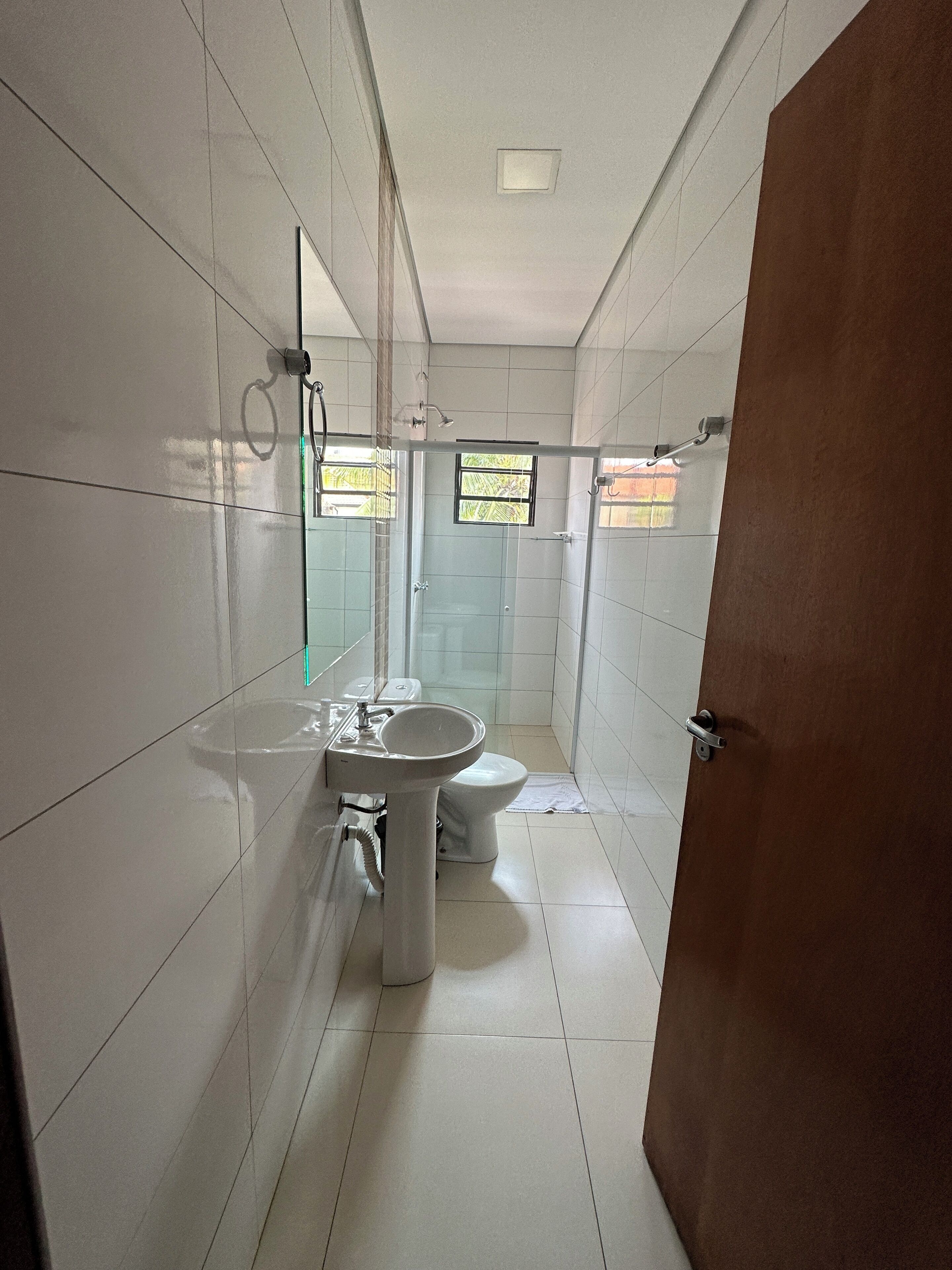 A bathroom with a toilet, sink, and shower area.