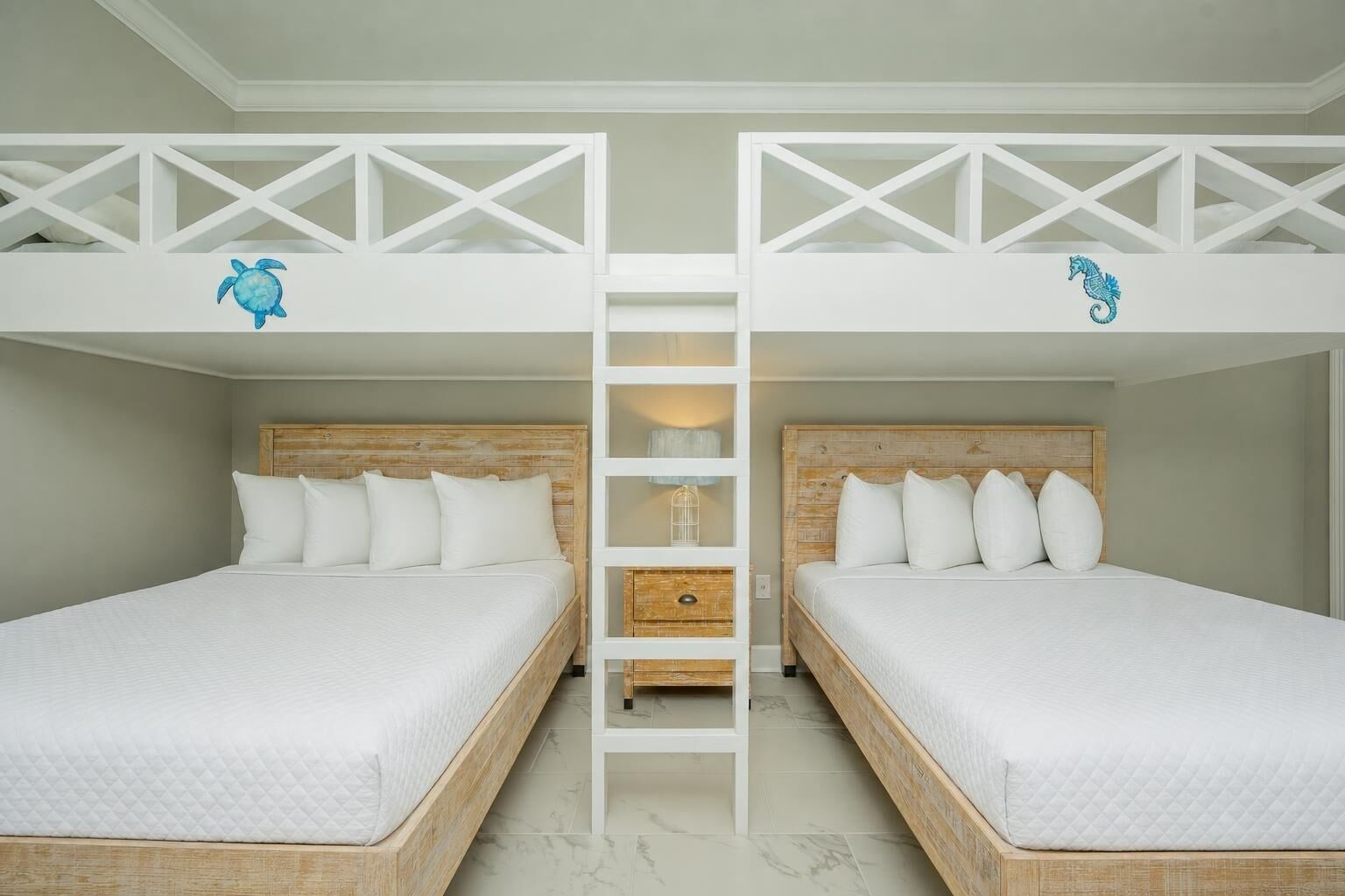 Une chambre avec deux lits superposés, une échelle et une tête de lit en bois.