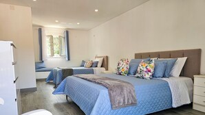 A hotel room with two beds, a wardrobe, a window with curtains, and a bedside table. - Little House of Heaven (Cortes do Meio)