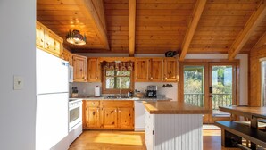 Una cocina amplia con armarios de madera, una isla central y una zona de comedor con banco.