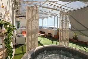 A rooftop terrace with a hot tub, outdoor seating, and a view of the city. - [Penthouse Facing the Sea-Center] (Salerno)