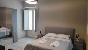 Una camera da letto moderna con un letto grande, un armadio e uno specchio.