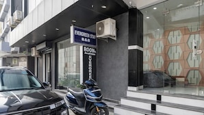 A modern building with a sign for 'Evergreen Stay B&B' and a scooter parked outside. - Hotel Evergreen Stay (New Delhi)