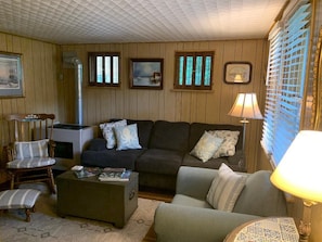 Una sala de estar acogedora con un sofá, sillones, una mesa de centro y una chimenea.