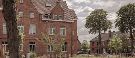 A red brick building with multiple windows and a sloped roof.