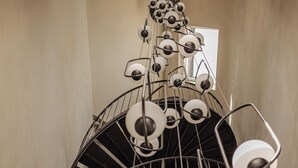Una escalera de caracol con diseño moderno, que incluye una serie de lámparas circulares.