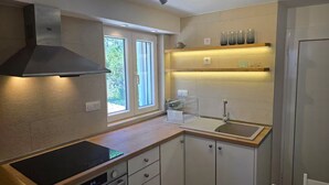 Eine moderne Küche mit Einbauherd, Spüle und einem Fenster für natürliches Licht.