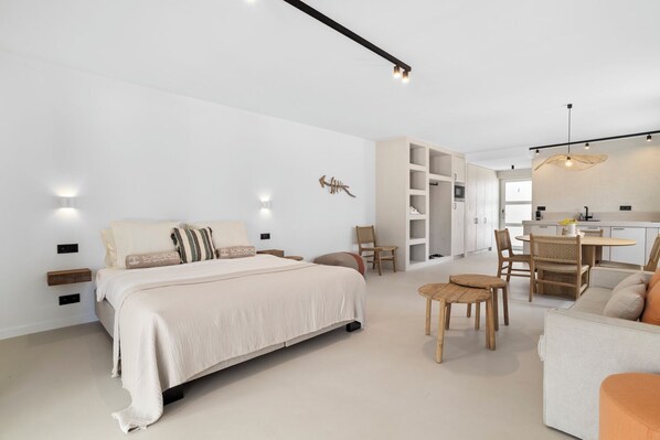Un dormitorio moderno con una cama grande, mesitas de noche, un escritorio y una silla.
